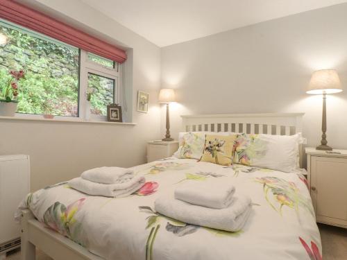 een slaapkamer met een bed met handdoeken erop bij T'whit T'woo in Windermere