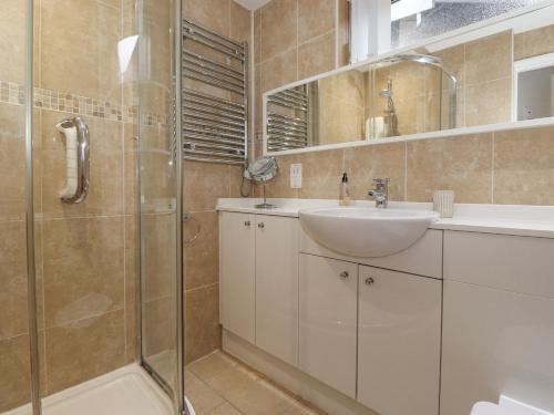 een badkamer met een wastafel en een douche bij T'whit T'woo in Windermere