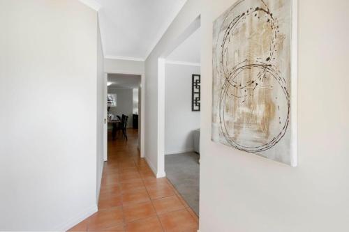 a hallway with white walls and a painting on a wall at Adelaide Hills 4 bed home near Hahndorf Mt Barker in Nairne