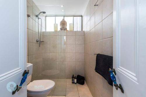 y baño pequeño con aseo y ducha. en 3 Bedroom House With Large Courtyard & City Views, en Sídney