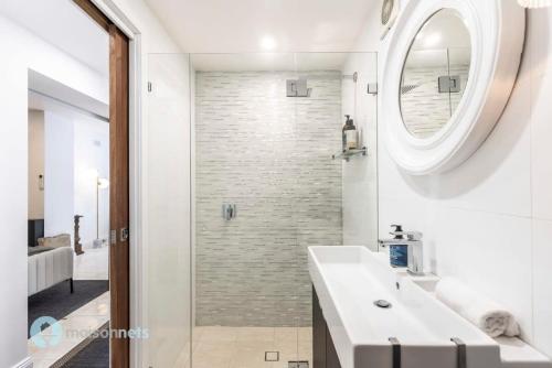 uma casa de banho com um lavatório branco e um espelho. em Annandale Sydney 2 Storey Cottage + Courtyard em Sydney