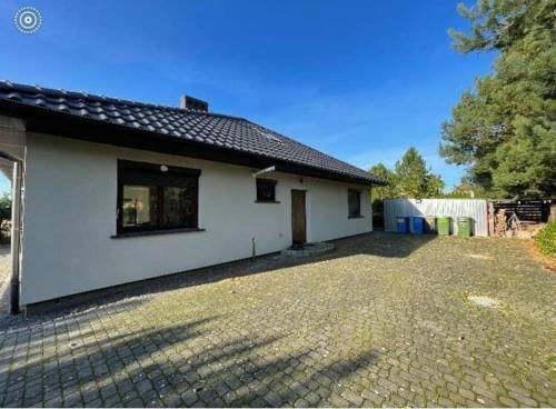 una casa blanca con una entrada delante de ella en Ferienhaus für 7 Personen und 1 Kind in Gaski, Ostseeküste Polen en Gąski