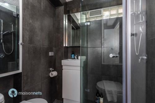 a bathroom with a shower and a toilet and a sink at Studio Gem With Rooftop Space Prime Location in Sydney
