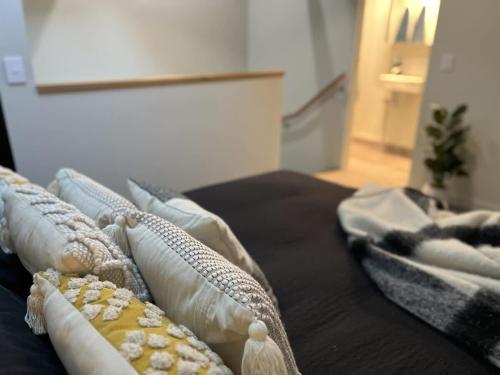 a bed with several pillows on top of it at Apt with Aircon & Loft Bedroom Great Location in Devonport