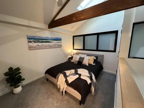 a bedroom with a bed in a room with windows at Apt with Aircon & Loft Bedroom Great Location in Devonport