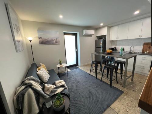 デボンポートにあるWell located Apt with Loft Bedroom & Airconのソファとテーブルのあるリビングルームとキッチン