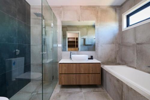 W łazience znajduje się umywalka, prysznic i wanna. w obiekcie 5 Bedroom 5 Bathroom Townhouse with Aircon w Melbourne