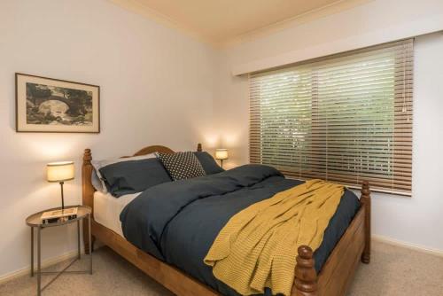 ein Schlafzimmer mit einem großen Bett und einem Fenster in der Unterkunft 3 Bdrm 2 Bthrm House Close to Canberra CBD & ANU in Canberra