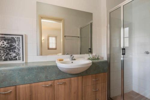 a bathroom with a sink and a glass shower at 3 Bdrm 2 Bthrm House Close to Canberra CBD & ANU in Canberra