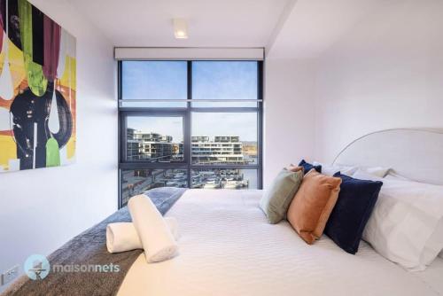 キャンベラにあるModern 2 Bdrm Apt with Water Views 2x Car Spotsの大きな窓のあるベッドのある寝室
