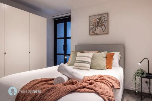 a bedroom with a bed with a blanket on it at Modern 2 Bdrm Apt with Water Views 2x Car Spots in Canberra