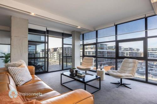 a living room with a couch and chairs and windows at Modern 2 Bdrm Apt with Water Views 2x Car Spots in Canberra