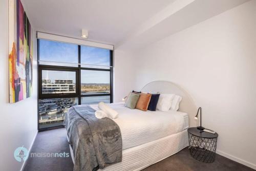 1 dormitorio con cama y ventana grande en Modern 2 Bdrm Apt with Water Views 2x Car Spots en Canberra