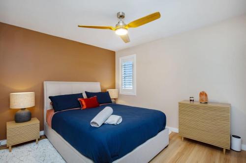 a bedroom with a blue bed and a ceiling fan at 1 Bedroom Gem with Aircon Stroll to Beach in Gold Coast