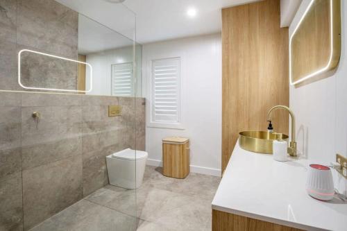 a bathroom with a toilet and a sink and a shower at 1 Bedroom Gem with Aircon Stroll to Beach in Gold Coast