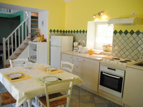 une cuisine avec une table et une cuisine aux murs jaunes dans l'établissement Gîte familial calme avec jardin, terrasse, équipements modernes et jeux pour enfants à Lentigny - FR-1-496-129, à Lentigny