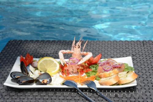a plate of food on a table next to a pool at Kiara Residence in Giulianova