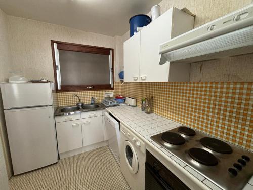 une cuisine avec un réfrigérateur blanc et un évier dans l'établissement Appartement 2 chambres face à la mer avec balcon et wifi - FR-1-197-428, à Les Sables-dʼOlonne