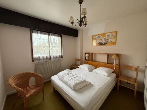 une chambre avec un lit, une chaise et une fenêtre dans l'établissement Appartement 2 chambres face à la mer avec balcon et wifi - FR-1-197-428, à Les Sables-dʼOlonne