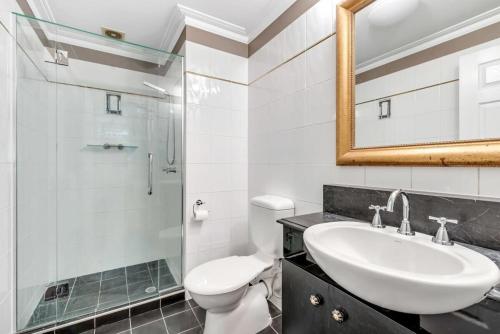 a bathroom with a sink and a toilet and a shower at Cozy Studio in Historic Brisbane CBD in Brisbane