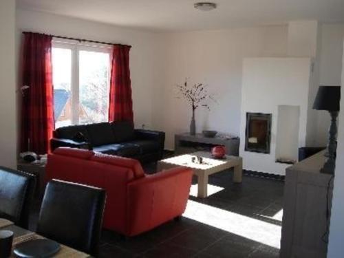 a living room with a red couch and a table at Ferienhaus für 10 Personen in Lipno nad Vltavou, Böhen Moldau in Lipno nad Vltavou