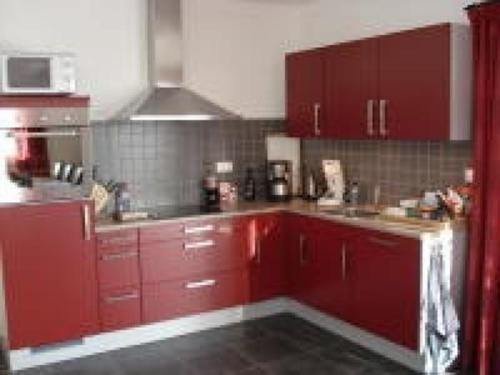 a kitchen with red cabinets and a microwave at Ferienhaus für 10 Personen in Lipno nad Vltavou, Böhen Moldau in Lipno nad Vltavou