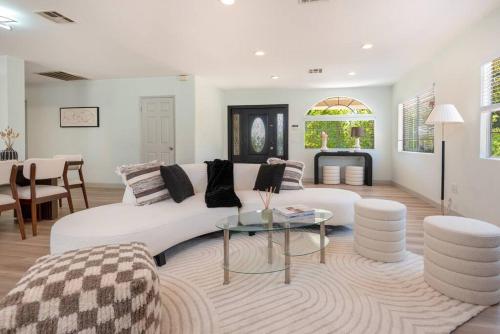 a living room with a white couch and a table at Luxurious 4-Bedroom Home with Pool & Jacuzzi! in Los Angeles