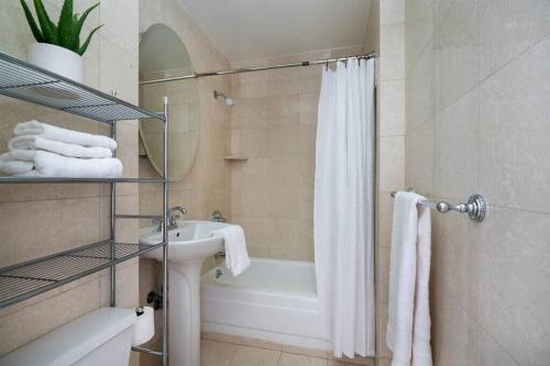 a bathroom with a tub and a sink and a shower at Luxury Elv Bldg 24H DM Gym Studio walk from C park in New York