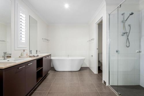ein Badezimmer mit Badewanne, Waschbecken und Dusche in der Unterkunft Getaway on the Rise in Portarlington