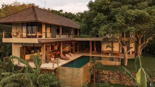 an external view of a house with a swimming pool at Villa Sorgas in Kuta Lombok