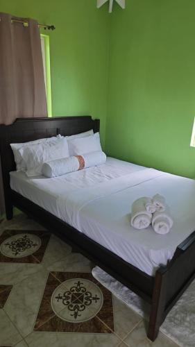 a bed with towels on it in a room at Rohan and Shelly's Inn in Castries