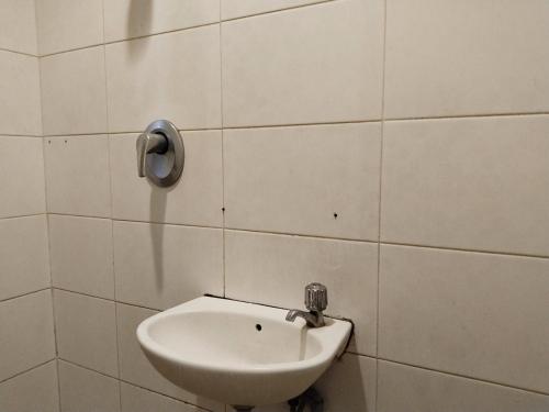 雅加達的住宿－Wisma Juanda Powered by Cocotel，瓷砖墙上带水槽的浴室