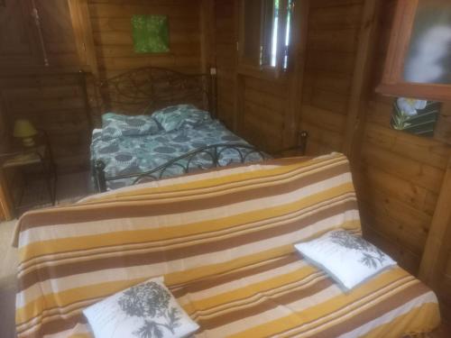 two beds in a wooden room with a bed at Gite de Germaine in Sainte-Anne