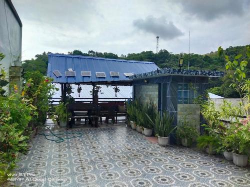 a house with a table and a blue roof at Catmel Lodging House in Romblon