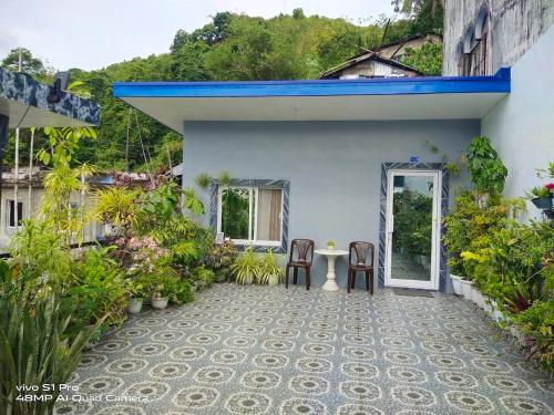 a patio of a house with a table and chairs at Catmel Lodging House in Romblon