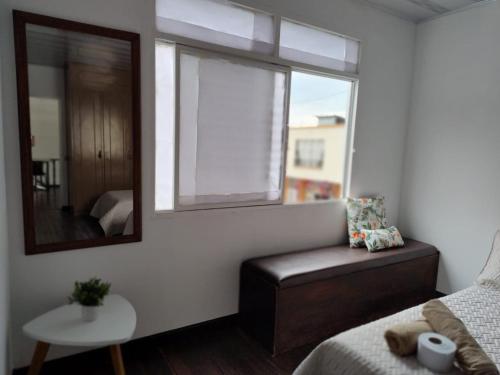 ein Schlafzimmer mit einem Bett, einem Fenster und einem Stuhl in der Unterkunft Casa Ambrosía in Calarcá