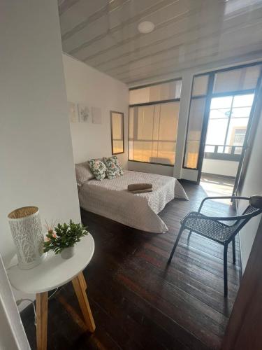 ein Wohnzimmer mit 2 Betten und einem Tisch in der Unterkunft Casa Ambrosía in Calarcá