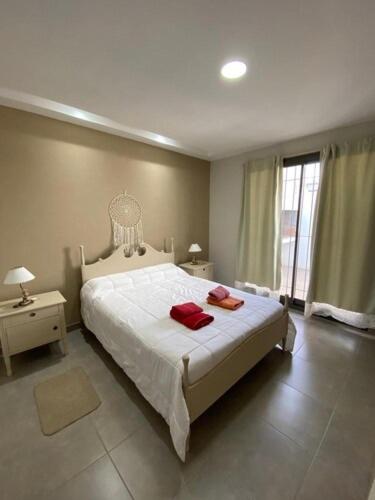 1 dormitorio con 1 cama con 2 toallas rojas en Casa de Carlita en La Consulta