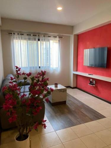 a living room with a couch and a flat screen tv at Departamento Oaxaca Bella in Oaxaca City