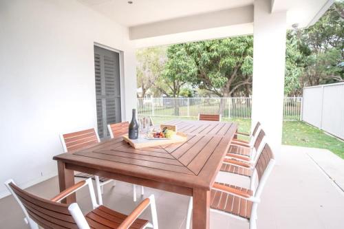 a wooden table and chairs on a patio at Golden Beach Family Home with Pool in Golden Beach