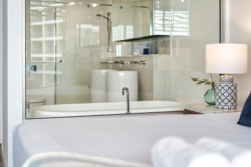 a white bathroom with a tub and a sink at Oracle Resort Broadbeach - gclr in Gold Coast