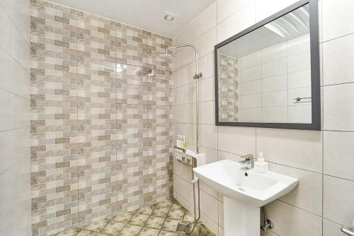 ein Bad mit einem Waschbecken und einem Spiegel in der Unterkunft Ciel mini hotel in Gyeongju