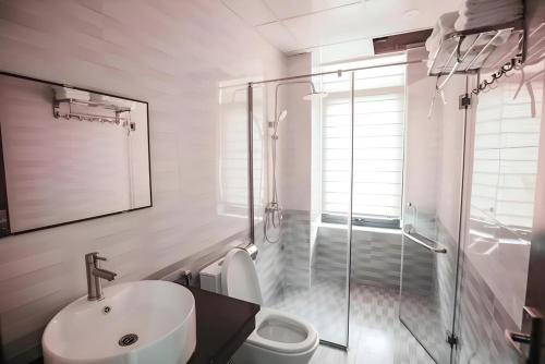 La salle de bains est pourvue d'un lavabo, d'une douche et de toilettes. dans l'établissement Khách sạn Xanh Tốt FLC Sầm Sơn, à Sầm Sơn