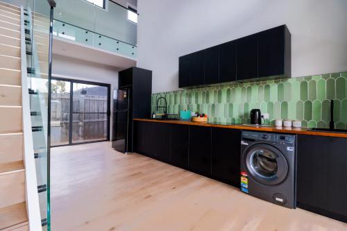 uma cozinha com uma máquina de lavar roupa num quarto em 239 High by Regional Escapes em Geelong