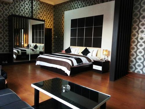 a hotel room with a bed and a mirror at Hotel Harmony In & Karaoke in Pontianak