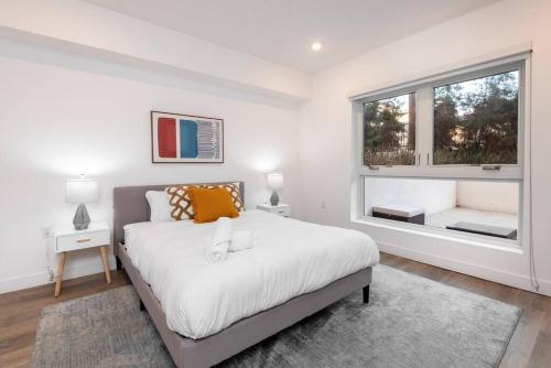 a white bedroom with a large bed and a window at Luxury 2 Bedroom In Larchmont Sleeps 4 W. Roof Top in Los Angeles