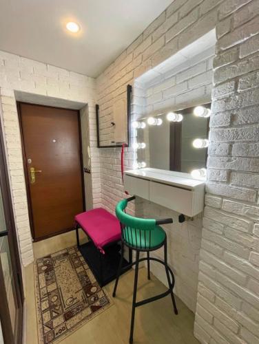ein Badezimmer mit einem rosa und grünen Stuhl und einer Theke in der Unterkunft 2х комнатная квартира Кайсенова 84 in Öskemen