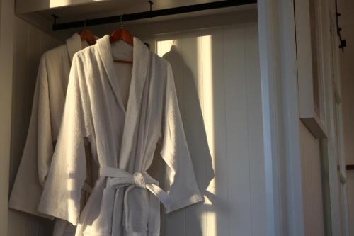 a white robe is hanging in a closet at The Firebreak 