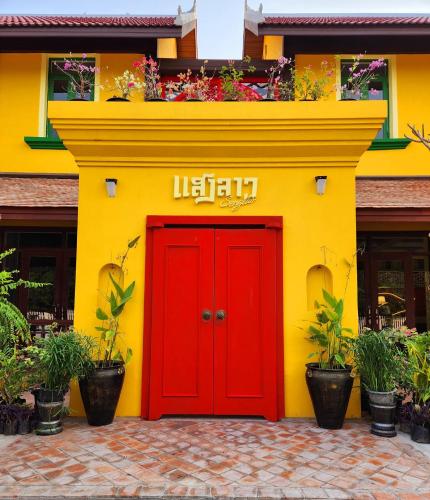 a yellow and red building with a red door at Senglao Boutique Hotel Luang Prabang in Luang Prabang