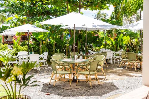 a group of tables and chairs with white umbrellas at Bahandi Hotel in General Luna